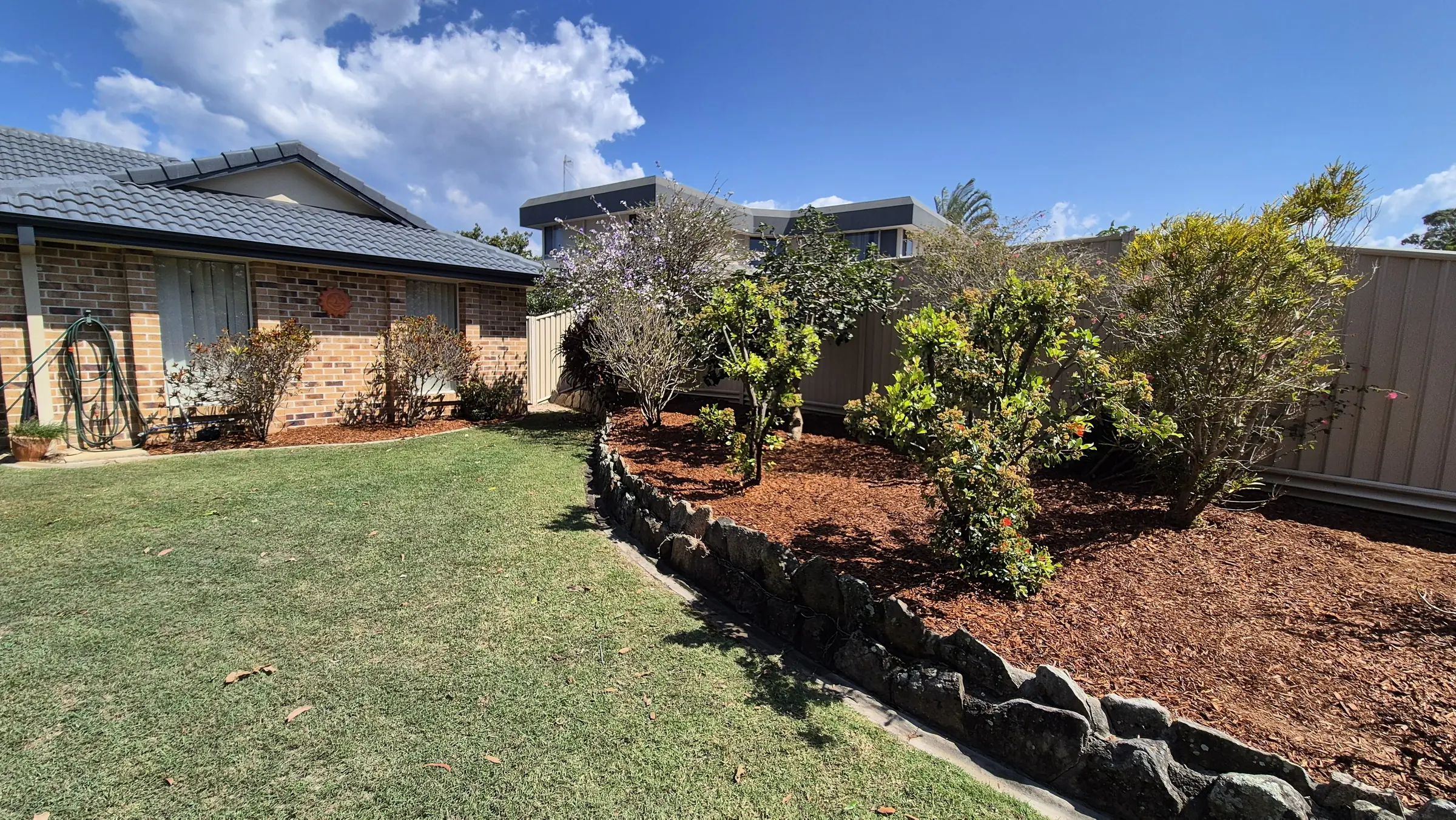 Mulched garden beds and mown lawn maintained by HWD Landscape & Maintenance
